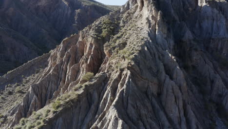 Atemberaubender-Felsvorsprung-In-Einer-Bergkette,-Luftschwenk-Nach-Rechts