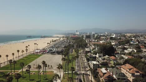 Los-Angeles-palm-tree-beachfront-property-coastline-aerial-rising-view-above-downtown-rooftops