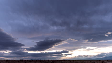 The-sky-threatens-rain-but-does-not-relieve-the-Mojave-Desert-landscape---sunset-time-lapse