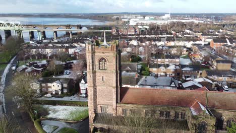Aerial-view-industrial-small-town-frosty-church-rooftops-neighbourhood-North-West-England-slow-orbit-right-to-Jubilee-bridge