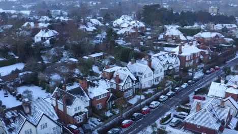 Drone-aerial-footage-of-Houses-in-England-on-a-Snowy-Morning-With-Rooftops-Covered-in-Snow-and-snow-in-gardens-in-English-town