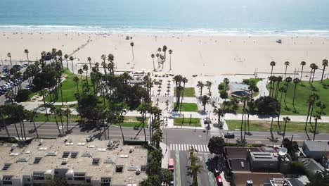 Aerial-view-above-Los-Angeles-palm-tree-beach-waterfront-neighbourhood-property-rooftops-dolly-left