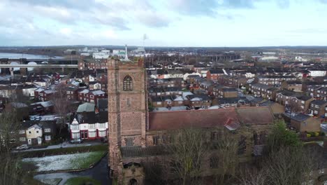 Aerial-view-industrial-small-town-frosty-church-rooftops-neighbourhood-North-West-England-orbit-left