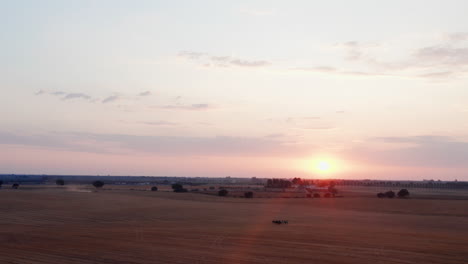 Luftaufnahme-Des-Farbenprächtigen-Sonnenuntergangs-Im-Hintergrund-Und-Herde-Grasender-Pferde-Auf-Dem-Feld