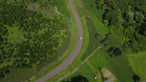 Aerial-View-Of-Road-In-The-Middle-Of-Green-Countryside-Fields-In-Kenya---static,-aerial-shot