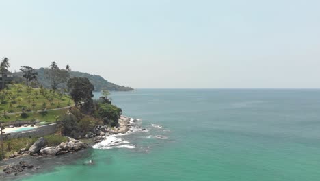 Rocky-landscape-meeting-the-Andaman-sea-parallaxing-with-the-other-shoreline---Aerial-Low-angle-slide-shot