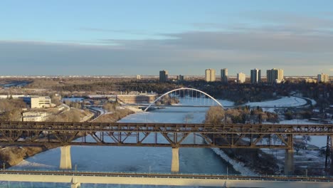 Winterflug-über-Die-Transitschiene-Moderne-Brücke-Neben-Der-Alten-Historischen-Low-Level-Brücke,-Die-Historisch-1910-Und-Erneut-1913-Aus-Stahl-Gebaut-Wurde-Und-Von-Beton-über-Den-North-Saskatchewan-River-1-5-Gehalten-Wird