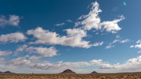 Clouds-roll-across-the-sky-above-the-rugged-terrain-of-the-Mojave-Desert---static-wide-angle-time-lapse