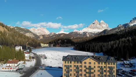 Slow-downward-pedestal-aerial-shot-of-Misurina-Lake-and-Italy's-Three-Peaks-of-Lavaredo-in-the-winter