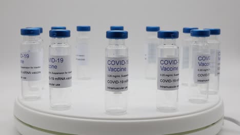 Transparent-empty-glass-vials-with-Covid-19-Vaccine-label-on-rotating-display
