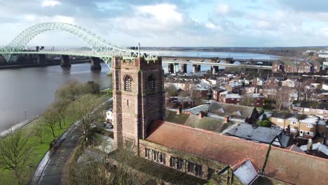 Aerial-view-industrial-Widnes-small-town-Jubilee-bridge-church-rooftops-neighbourhood-North-West-England-descending