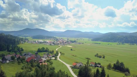 Luftaufnahme-Zum-Kleinen-Slowenischen-Dorf-In-Den-Bergen-Mit-Einigen-Schönen-Feldern