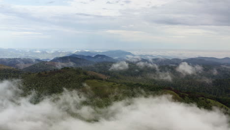 Atemberaubender-Drohnenblick-Auf-Bewölkte-Berge-Am-üppigen-Morgen-Grüner-Hügel,-Die-Von-Tropischen-Regenwolken-Bedeckt-Sind