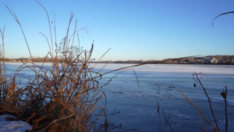 Pan-shot-of-a-frozen-lake-in-winter-by-sunset