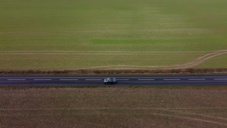 Una-Carretera-Rural-Asfaltada-Negra-Disparada-Por-Un-Dron