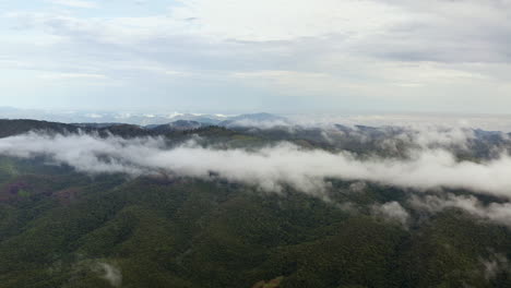 Aerial-Drone-View-Shot-of-Cloudy-Mountains-in-The-Lush-Morning-of-Green-Hills-Covered-by-Tropical-Rain-Clouds
