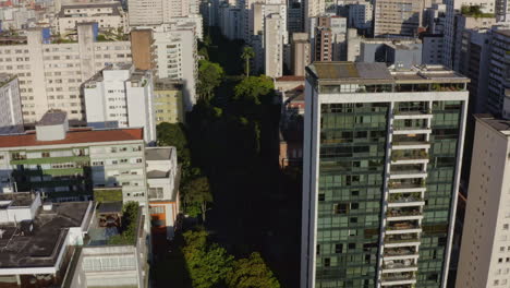 Drone-Aerial-Shoot-of-a-Big-Metropolis-Passing-Through-Big-Buildings-on-Sao-Paulo-city,-Brazil,-Dolly-In-and-Tilt-Down-to-the-Streets-of-Higienopolis-District