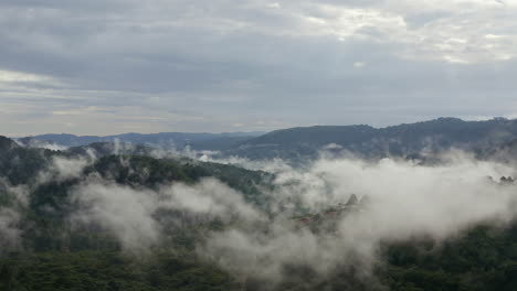 Faszinierender-Drohnenblick-Auf-Bewölkte-Berge-Am-üppigen-Morgen-Grüner-Hügel,-Die-Von-Tropischen-Regenwolken-Bedeckt-Sind