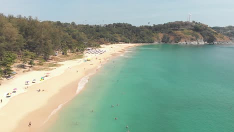 Idyllic-Turquoise-shoreline-and-paradisiac-setting-of-Nai-Harn-Beach-in-southern-Phuket,-Thailand---Aerial-low-angle-Fly-over-shot
