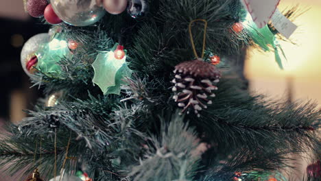 Cute-Frosted-Pine-Cone-Pendant-And-Baubles-Hanging-On-Christmas-Tree---Closeup,-Slider-Shot