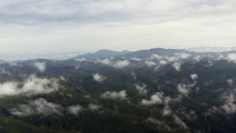 Drohnenblick-Auf-Bewölkte-Berge-Am-üppigen-Morgen-Grüner-Hügel,-Die-Von-Tropischen-Regenwolken-Bedeckt-Sind