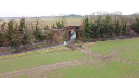 Drohnenaufnahmen,-Die-Von-Der-Eisenbahnbrücke-Im-Ländlichen-Dorf-Kent-Wegfliegen