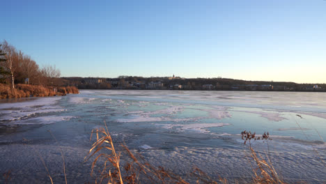 Pan-shot-of-a-frozen-lake-in-winter-by-sunset