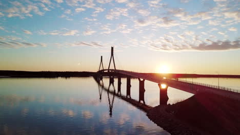 Aerial-shot-of-Replot-bridge-during-sunset-with-water-reflection