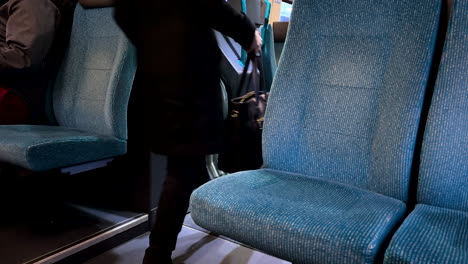 Ein-Leerer-Sitzplatz-Aus-Einem-Rustikalen-Zug-Mit-Vorbeifahrenden-Passagieren-Bei-Tageslicht
