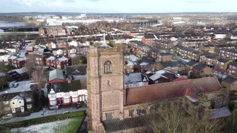 Aerial-orbit-right-view-industrial-small-town-frosty-church-rooftops-neighbourhood-North-West-England