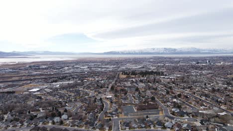 Aerial-shot-of-Provo-city-suburbs,-Utah-Lake-and-mountains-in-background