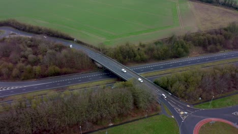 Drone-footage-of-moving-cars-and-lorries-going-over-a-bridge-over-the-A2-dual-carriage-way