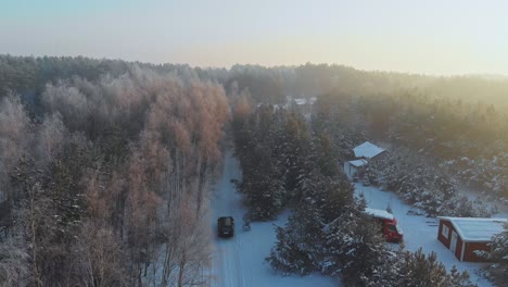 Aerial-shot-following-a-car-driving-in-a-snowed-forest