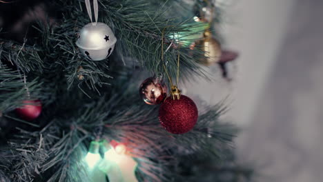 Coloridos-Adornos-Navideños,-Hojas-De-Acebo-Y-Luces-Decorativas-Alrededor-Del-árbol-De-Navidad