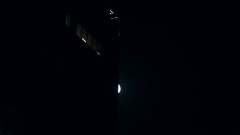 Luna-Brillante-En-El-Cielo-Nocturno-Escondiéndose-Lentamente-Detrás-Del-Edificio
