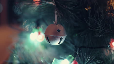 Hängende-Weihnachtsbaumkugel-Aus-Metall-Mit-Sternlochdesign-Mit-Bokeh-Lichthintergrund---Nahaufnahme