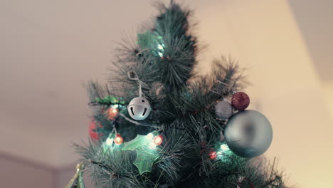 Verschiedene-Ornamente-Von-Weihnachtskugeln-Hängen-Im-Winter-An-Der-Baumkrone-Mit-Beleuchteten-Bunten-Girlandenlichtern
