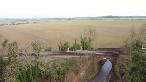 Drone-footage-flying-alongside-train-tracks-including-a-bridge-in-Kent