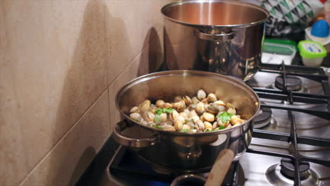 Chef-adding-some-fresh-parsley-into-pot-of-cooking-clams-in-Portuguese-kitchen