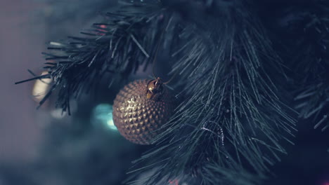 Diamond-Patterned-Vintage-Brass-Christmas-Bauble-On-Christmas-Tree---Closeup,-Slider-Shot