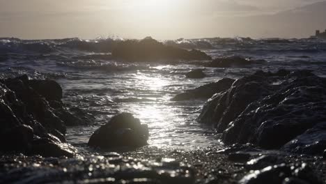 Ocean-tide-coming-by-in-slow-motion-between-the-rocks-at-the-beach