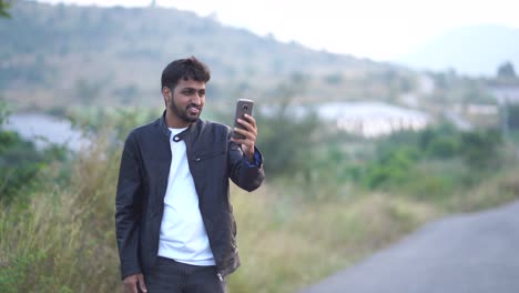 Portrait-of-smiling-boy-having-video-call-by-mobile-phone-outdoors