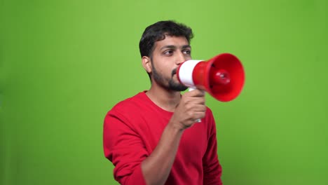 Man-indian-shouting-through-a-megaphone-on-green-screen-chroma-key