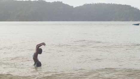 Girl-dancing-and-enjoying-herself-in-the-waters-of-the-north-coast-of-Trinidad