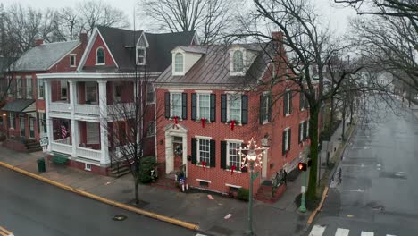 Aerial-of-restored-historic-red-brick-home,-decorated-for-Christmas-holiday