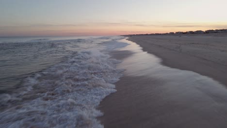 Wellen,-Die-Im-Sand-Krachen,-Und-Ein-Wunderschöner-Nachmittagssonnenuntergang---Bewegter-Mittlerer-Schuss-Aus-Der-Luft