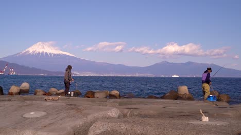 Fishermen-in-Japan-fishing-from-stone-pier-with-Mt