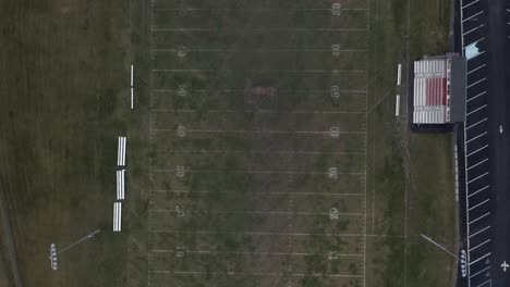 Drone-top-shot-of-an-empty-American-football-field-while-snowing