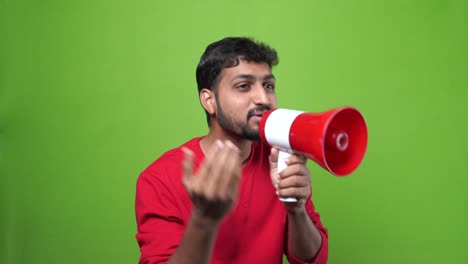 Indian-man-shouting-with-a-megaphone-over-a-green-screen-background