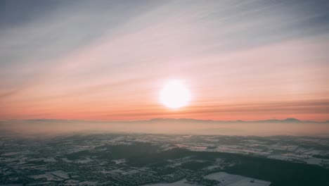 Ein-Sonnenuntergang-über-Einem-Schneebedeckten-Wald,-Drohne-4k
